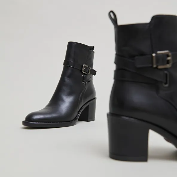 Heeled ankle boots and buckles in black leather