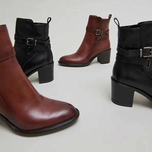 Heeled ankle boots and buckles in black leather