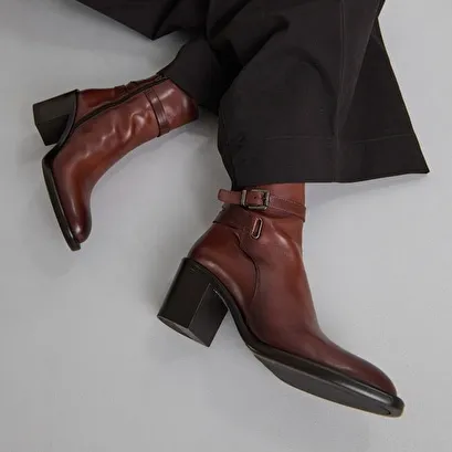 Heeled ankle boots and buckles in cognac leather