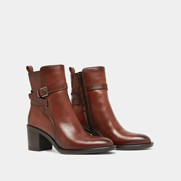 Heeled ankle boots and buckles in cognac leather