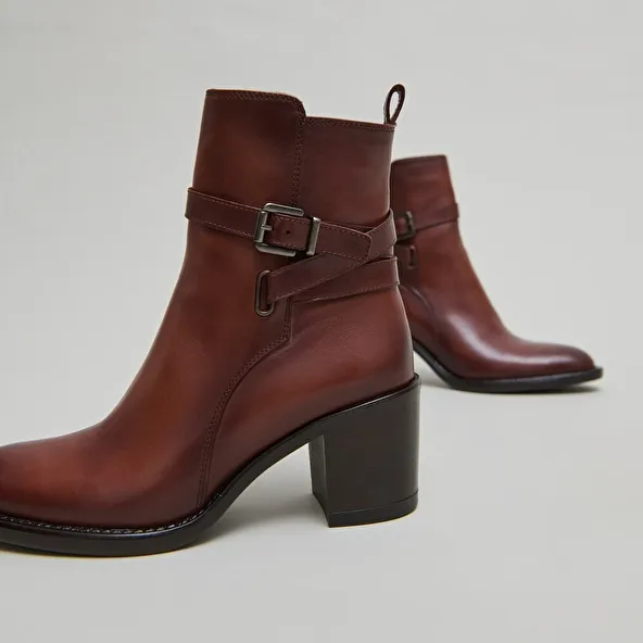 Heeled ankle boots and buckles in cognac leather